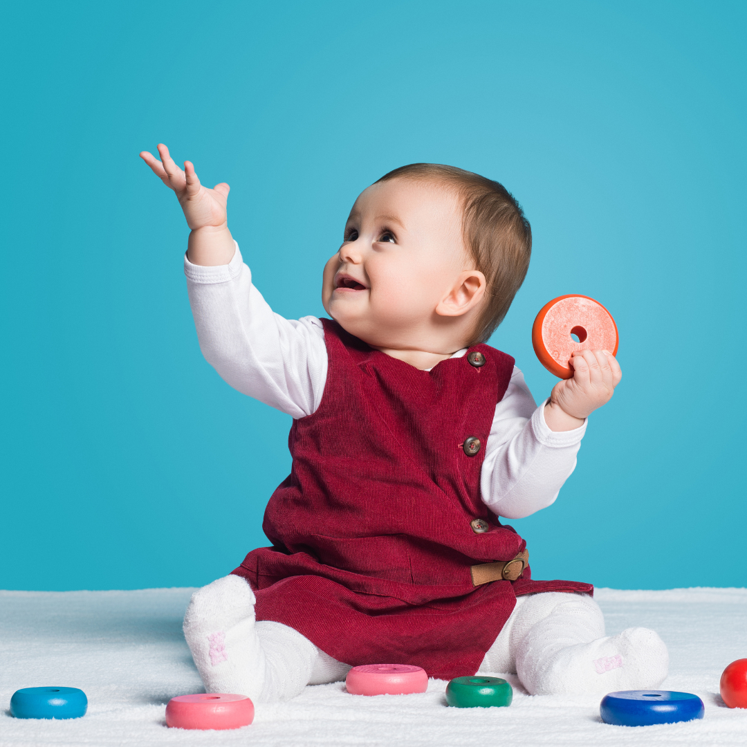 Smiling baby playing with donut toys