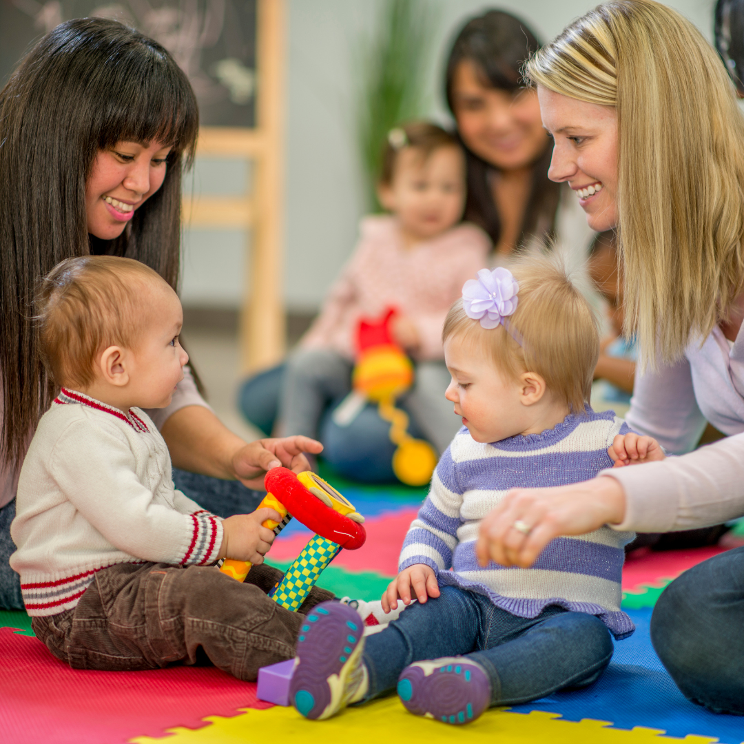 Two women playing with children at daycare