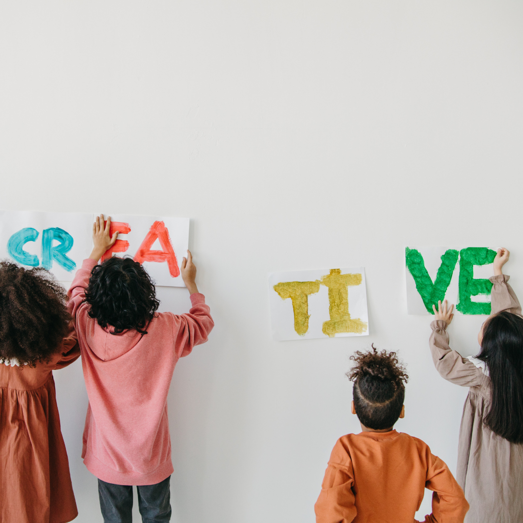 kids posting signs that spell out creative