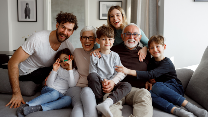 family sitting on couch and smiling 